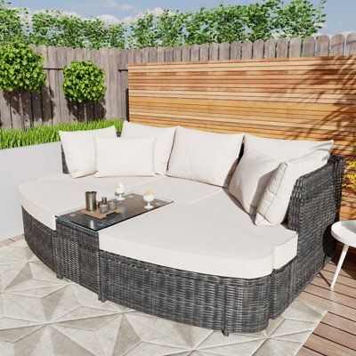 This patio daybed offers a graceful, minimalist design that's perfect for any outdoor setting from the backyard to poolside. The PE wicker frame provides a robust and weather-resistant foundation, while the arc-shaped sofa edges and ottomans fit together to create a comfortable double lounger. This outdoor sofa set includes an end table with a glass top, perfect for holding drinks or books as you relax. The modular design allows flexibility in your outdoor furnishing layout, and the thick cushio