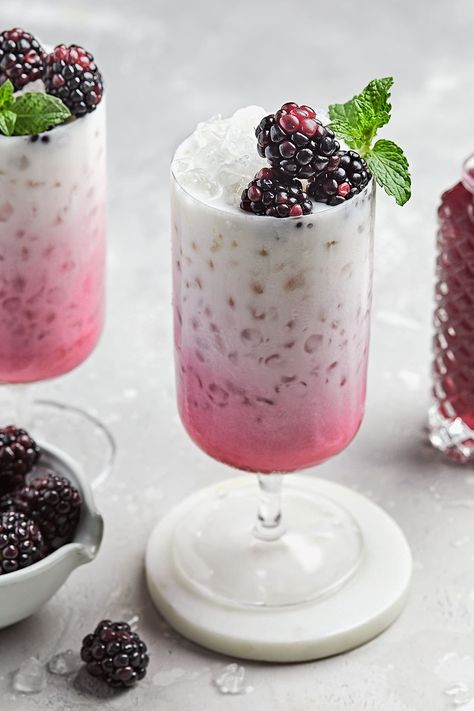 This beautiful and bubbly Italian Soda Recipe combines sparkling water, low-carb blackberry syrup, and heavy cream served over ice and garnished with fresh blackberries and mint. A crisp, refreshing beverage that’s fun, sweet, and low-carb! Dairy-free option included. Mocktails With Poppi Soda, Poppi Soda Mocktail, Olipop Soda Mocktail, Italian Soda Recipe, Soda Mocktail, Caramel Apple Pops, Halloumi Salad, Blackberry Syrup, Blackberry Recipes