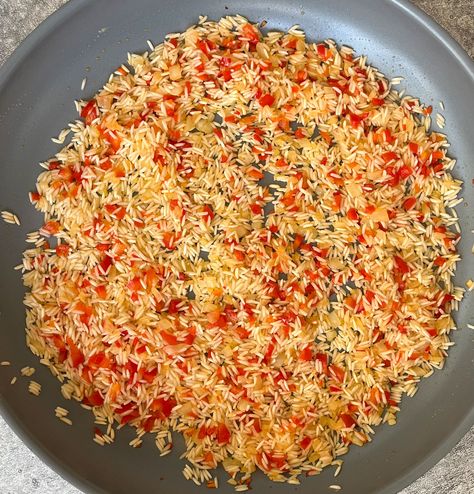 There is chopped onion, red bell pepper, and white rice cooking in a large gray skillet. Bell Pepper Rice, Chile Relleno Casserole Recipe, Starchy Sides, Pepper Rice, Chicken Piccata Recipe, Longhorn Steakhouse, Savory Rice, Itunes Card, Popular Side Dishes