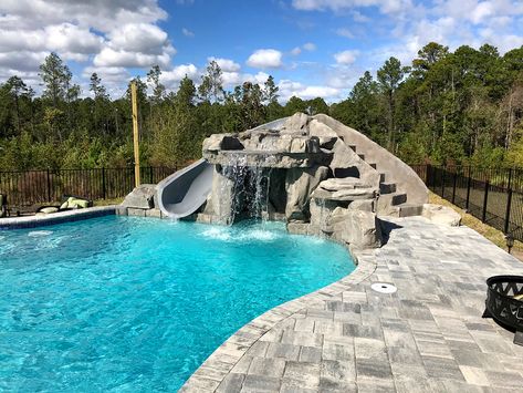 This gorgeous Florida pool features a RicoRock faux rock grotto, waterfall, and miscellaneous boulders in grey colors to match the pool deck.  Credit: Coastal Coating And Resurfacing, FL Grotto Waterfall, Plastic Swimming Pool, Swimming Pool Images, Swimming Pool Waterfall, Cool Grey Color, Swimming Pool Pictures, Company Ideas, Pool Shade, Florida Pool