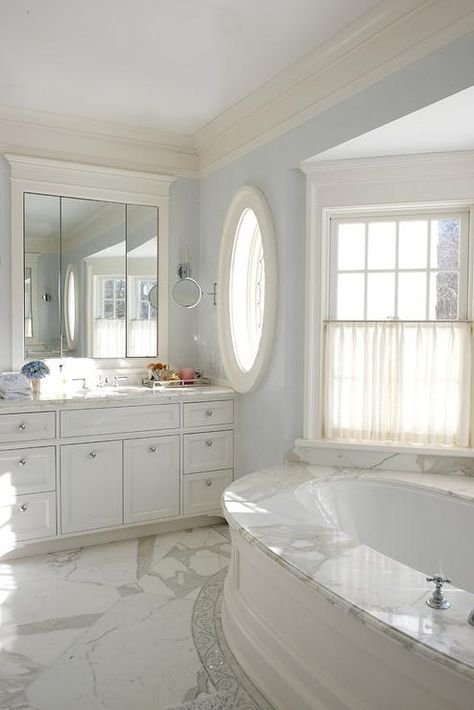 Elegant white and blue master bathroom features a wainscot oval drop-in bathtub fitted with a marble deck positioned beneath a bay window dressed in cream cafe curtains. Drop In Tub, Bathroom White, Bathtub Remodel, Dream Bathrooms, Covent Garden, Bathtubs, Bath Tub, Bathroom Remodel Master, Bath Remodel