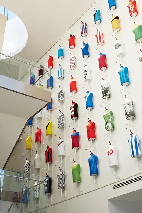 The Football Centre reception at St George’s Park – the English Football Association’s impressive national training facility – is set in a large roof-height atrium. Our creative agency client wanted to use the extensive wall space to display The FA’s fascinating collection of England team shirts. We built special mannequin mounting frames with integral spot lights and installed them up to ceiling level. #commercialinteriordesign #interiordesignforbusiness Interior Millwork, England Team, Millwork Details, Sports Office, Soccer Highlights, Diy Home Gym, Travel Retail, History Wall, Training Facility