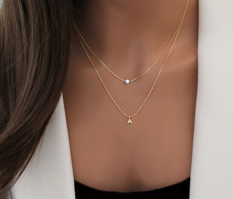 "LAYERED OPAL INITIAL BIRTHSTONE NECKLACE Minimal layered necklace set with a romantic shimmering lab opal and a dainty initial letter just for you. Subtle attention-grabber that pairs nicely with many different ensembles. See information on lab opals below. IT'S IN THE DETAILS - 14K Gold Filled, Sterling Silver chain - Two separate necklaces, each with their own clasp - Your choice of birthstones. (4mm) See photo #3 and #4 for samples - BLOCK or SCRIPT Letter Charm in Gold Filled* or Sterling S Attention Grabber, Jupiter Fl, Stacked Necklaces, December 24th, Handmade Jewelry Gift, Letter Charms, Keep Jewelry, Opal Necklace, Natural Opal