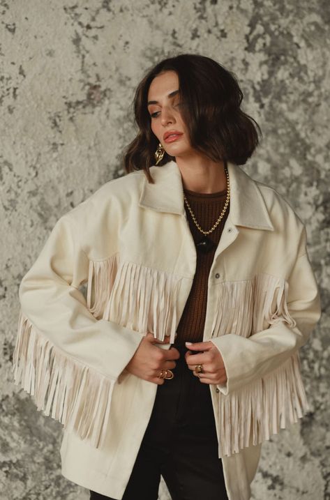 You can never have too much fringe! Grab the Piper Bone Fringe Jacket to elevate your fit and add extra warmth this season. Throw over your chunky sweater, pair with your favorite denim, and you are looking 10/10! STYLE RECOMMENDATIONS: - designed slightly oversized - throw over your basics to elevate your look PRODUCT DESCRIPTION AND MATERIALS: - bone fringe jacket - fringe on the front and sleeve seams - snap button front closure - lined - shell: 100% polyester - lining: 100% polyester - fring Fringe Jacket Outfit, Fringe Wedding Dress, Shacket Outfit, Fringe Coats, 12th Tribe, Throw Over, Fringe Jacket, Chunky Sweater, Faux Fur Jacket