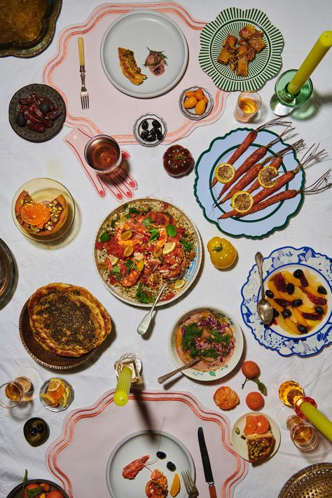 A Moroccan-inspired table setting with colorful plates set on a white linen tablecloth and a variety of dishes including an orange & olive salad, goat cheese cigars, and tagines. Moroccan Dinner Party, Moroccan Dinner, Moroccan Salad, Indian Dinner, Citrus Salad, Salad Dishes, Dried Vegetables, Dinner Party Recipes, Bread Serving