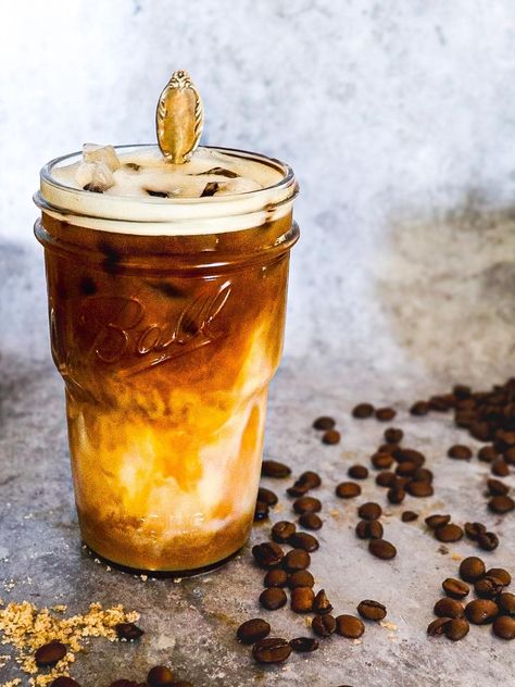 Shaken brown sugar espresso topped with vanilla sweet cream.  Coffee beans are scattered around. How To Make Brown Sugar Shaken Espresso, Brown Sugar Shaken Espresso Starbucks, Brown Sugar Cold Brew Coffee, Keto Brown Sugar Shaken Espresso, Brown Sugar Shaken Espresso, Vanilla Syrup For Coffee, Honey Nut Cheerios, Espresso Recipes, Copycat Starbucks Recipes