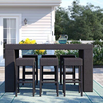 Sol 72 Outdoor™ Create a relaxing getaway for your next backyard get-together with this 7-piece bar height dining set. It's crafted with sleek, modern lines from resin wicker-wrapped aluminum frames for year-round weather resistance. The high top table features a glass tabletop on a simple wicker base. Six backless bar stools give friends and family plenty of seating room to gather round the pub table. The table has a space-saving open bottom where you can tuck the stools when you're not using t Outdoor Bar Sets, Bar Patio, Nursery Furniture Sets, Patio Bar, Glass Top Table, Bar Height, Patio Dining Set, Cool House Designs, Outdoor Bar