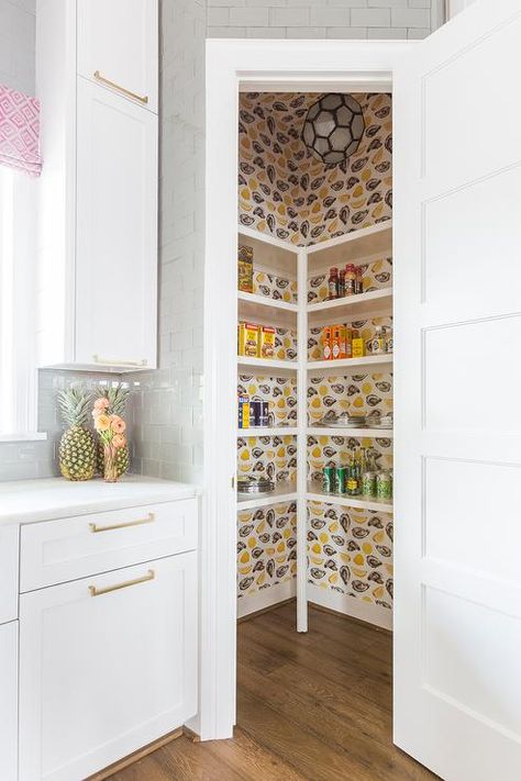 Cute  walk-in pantry is covered in Katie Kime The World is Your Oyster Wallpaper and fitted with stacked white shelves lit by a faceted pendant. Ivory Kitchen Cabinets, Katie Kime Wallpaper, Pantry Wallpaper, Closet Wallpaper, Pantry Interior, Kitchen Photography, Katie Kime, Pantry Wall, Under Stairs Cupboard