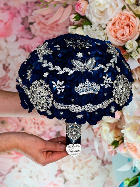 Behold the exquisite Quinceañera brooch bouquet in Navy Blue with silver colors! This quince bouquet shines with luxury and splendor, made with carefully chosen brooches of different shapes and sizes, crafted by hand.A handle wrapped in navy satin ribbon with attached heart that adds a personalized touch. This brooch bouquet is not only a beautiful accessory but also a cherished keepsake that captures the essence of your Quinceañera party. Bouquet size: 9 inches L x 13 inches HHand-made.Can be p Quinceanera Memory Ideas, Navy Blue Quinceanera Ideas Decor, Royal Blue And Silver Quinceanera Theme, Midnight Blue Quinceanera Theme, Dark Blue Quinceanera Theme, Royal Blue Quinceanera Ideas, Navy Blue Quinceanera Ideas, Under The Stars Quinceanera Theme, Royal Blue Quinceanera Theme