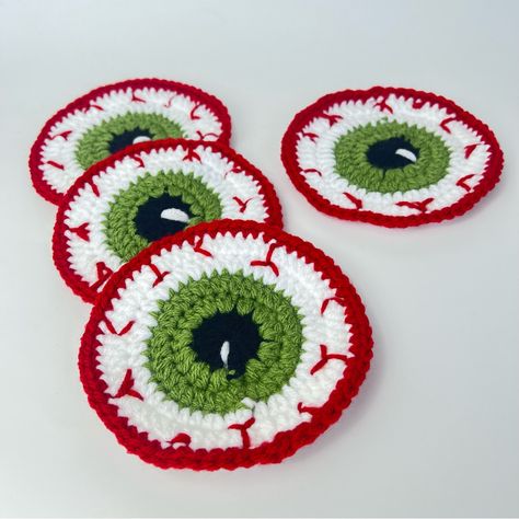 Spooky Set Of 4 Handcrafted Crochet Halloween Eyeball Coasters Handmade By Me Get Ready To Spook Up Your Halloween Decor With This Handcrafted Crochet Eyeball Coaster! Perfect For Adding A Creepy Yet Fun Touch To Your Party Or Coffee Table. Made With Love And Attention To Detail, This One-Of-A-Kind Coaster Is Sure To Be A Conversation Starter At Your Halloween Gatherings. Grab It Now To Add A Ghoulishly Delightful Twist To Your Home! 100% Acrylic Yarn Measurements Approximately 4 1/2” Halloween Small Practical Crochet Projects, Crocheted Halloween Decorations, Crochet Patterns Halloween Free, Eyeball Halloween Decor, Crochet Halloween Ornaments, Halloween Crochet Coasters, Crochet Halloween Coasters, Halloween Crochet Decor, Red Halloween Decor