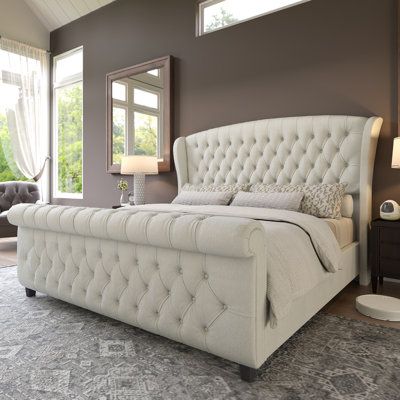 Transform your bedroom into a luxurious sleep space with this low-profile sleigh bed. The elegantly curved headboard is upholstered in rich chenille fabric, and it showcases deep diamond-shaped button tufting, giving your space a sophisticated look. Made from engineered wood, this bed frame has 12 wooden slats and center support legs for a stable foundation - no box spring is needed. The foam-filled headboard offers an inviting place to lean back and enjoy a good book or your favorite TV show. P