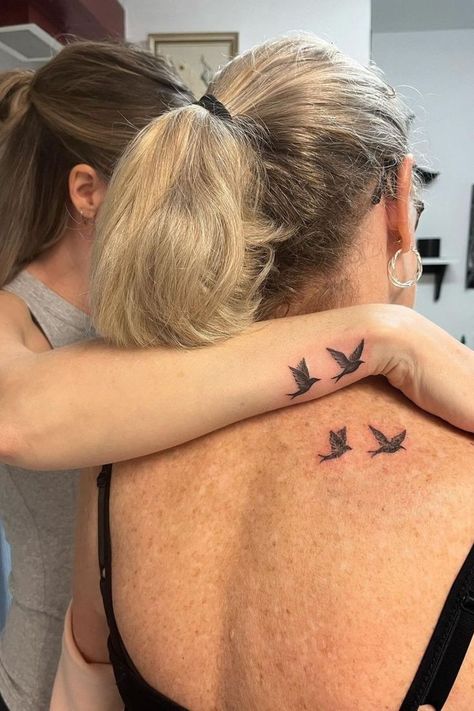 Matching mother-daughter tattoos featuring small birds in flight on the back and wrist, symbolizing freedom and connection. Mother Daughter Tattoos Hummingbird, Mother Daughter Bird Tattoos, Grandmother Mother Daughter Tattoos, Mom And Daughter Tattoos Matching Small, Daughter Mother Tattoos, Mom And 2 Daughter Tattoos, Matching Mother And Daughter Tattoos, Matching Mom Daughter Tattoos, Mum Tattoos