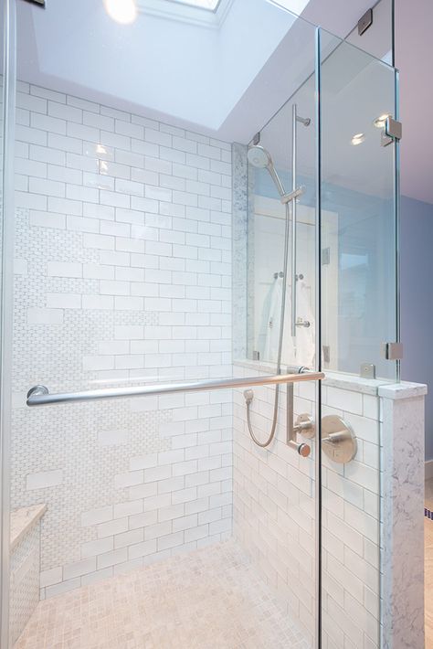 The master shower features an adjustable shower head mounted to the frameless glass enclosure. An existing skylight enhances the open and airy feeling in the room. Exposed Shower Plumbing, Bathroom Glass Wall, Exposed Plumbing, Glass Shower Wall, Shower Plumbing, Bathroom Plan, Bathroom Design Layout, Grab Bars In Bathroom, Shower Controls