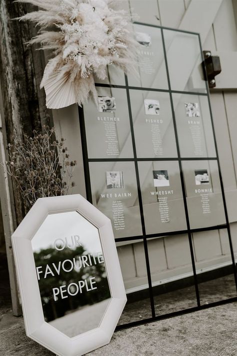 Window wedding seating chart with black and white photos, mirror wedding sign, and white dried wedding flowers with pampas grass and dried palm leaves Wedding Flowers With Pampas, Dried Palm Leaves Wedding, Pampas Grass Diy, Flowers With Pampas, Wedding Signage Ideas, Window Seating Chart, Mirror Wedding Sign, Unique Seating Chart Wedding, Palm Leaves Wedding