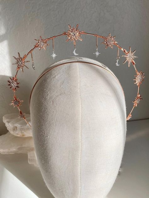 Handmade and one of a kind, this stunning golden halo is the perfect crown to finish off any look. Perfect for the bohemian, dreamy bride, this crown sits comfortably on the head and makes you shine without getting in the way. Stunning starburst embellishments in rose gold, with silver northern polaris stars and crescent moons dangling and swaying with your movements. The mixture of metals give a rich and unique look to truly make you stand out. They rest on a stunning rose gold halo, this headp Celestial Halo Crown, Star Halo Crown, Wedding Halo Crown, Moon Halo Crown, Halo Crown Headpieces, Golden Halo Crown, Crown Of Stars, Starfall Ball, Celestial Crown