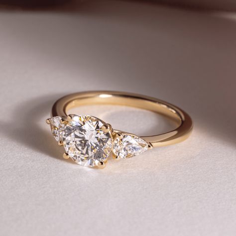 Exceptional lab-grown diamond ring showcasing a trilogy of sparkling round brilliants, totaling 1.25 carats, set in lustrous 14K/18K yellow/white/rose gold. This exquisite three-stone ring symbolizes the past, present, and future of your love, making it a perfect engagement or anniversary gift. 𝐅𝐞𝐚𝐭𝐮𝐫𝐞𝐬:• 𝐌𝐚𝐝𝐞 𝐭𝐨 𝐎𝐫𝐝𝐞𝐫• 𝐌𝐞𝐭𝐚𝐥: 𝟏𝟒𝐊 𝐆𝐨𝐥𝐝 | 𝟏𝟖𝐊 𝐆𝐨𝐥𝐝 | 𝟗𝟓𝟎 𝐏𝐥𝐚𝐭𝐢𝐧𝐮𝐦• 𝐁𝐚𝐧𝐝 𝐂𝐨𝐥𝐨𝐫𝐬: Rose Gold, Yellow Gold & White Gold• 𝐁𝐚𝐧𝐝 𝐖𝐢𝐝𝐭𝐡: 1.80 MM• 𝐁𝐚𝐧𝐝 𝐓𝐡𝐢𝐜𝐤𝐧𝐞𝐬𝐬: 1.60 MM 𝐂𝐞𝐧𝐭𝐞𝐫 𝐬𝐭𝐨𝐧𝐞:• 𝐒𝐭𝐨𝐧𝐞 - Lab Grown Diamond• 𝐒𝐡𝐚𝐩𝐞 - Brilliant Cut Round• 𝐂𝐚𝐫𝐚𝐭 𝐖𝐞𝐢𝐠𝐡𝐭 - 1.25 Carats• 𝐏𝐢𝐞𝐜𝐞𝐬 - 1 Piece• 𝐂𝐨𝐥𝐨𝐫 - F+• 𝐂𝐥𝐚𝐫𝐢𝐭𝐲 - VS1+• 𝐂𝐞𝐫𝐭𝐢𝐟𝐢𝐜𝐚𝐭𝐞 - 𝐈𝐆𝐈 | 𝐆𝐈𝐀 𝐒𝐢𝐝𝐞 𝐬𝐭𝐨𝐧𝐞𝐬:• Three Stone Engagement Rings Gold, Three Stone Engagement Rings Round, 3 Diamond Engagement Rings, Three Diamond Engagement Ring, Past Present Future Ring, Gold Band Engagement Rings, Trilogy Engagement Ring, Yellow Engagement Rings, Three Stone Engagement Ring