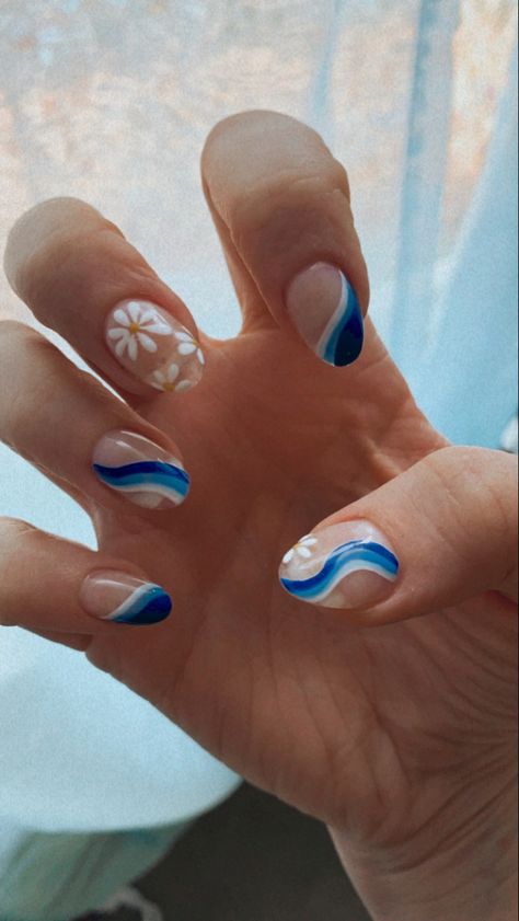 Retro 70s blue wave & flower nail art, acrylic nails, clear base, dark - medium - blue lines & white line on all fingers except middle, middle finger with retro white flowers

Nail art done by Rino Nail Bar in Denver, CO Flower And Squiggle Nails, Blue Themed Acrylic Nails, Wave Nail Art Simple, White 70s Nails, Retro Wave Nails, Blue Groovy Nails, 70s Nails Retro Blue, Blue 70s Nails, Blue Waves Nails