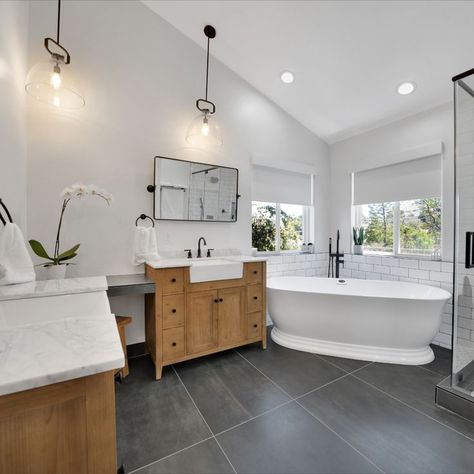 Talk about a dream bathroom. This Master Bathroom has the gorgeous designer double vanities, with large, dark slate tiles for the floor, stylish pendant lighting and an amazing stand alone tub next to their enlarged shower enclosure. The matte black finishes and abundance of natural light bring the whole room together. Dark Vs Light Bathroom Floor, Slate Tile Floor Bathroom Ideas, Slate And Marble Bathroom, Bathroom With Slate Floor, Master Bath With Dark Floors, Master Bath Dark Floor, Slate Tile Bathroom Floor, Black Slate Bathroom Floor, Bathroom With Dark Floors