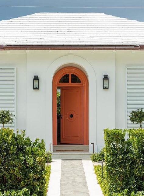 Bungalow features an orange front door illuminated by black lanterns. Rust Front Door, Transitional Home Exterior, Orange Front Doors, Black Lantern, Bungalow, Front Door, Lanterns, House Exterior, Doors