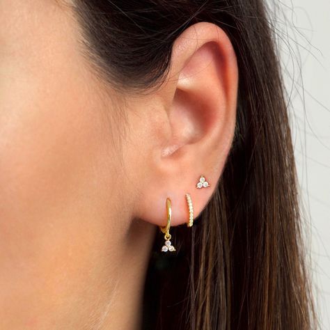 "Dainty and beautiful, these tiny studs are adorned with three bright prong-set cubic zirconia gemstones. An everyday staple piece, perfect for wearing in a first, second or third earhole or on a cartilage piercing for a dainty addition to your look. * Sold as a PAIR * D E T A I L S * ∙ Material: .925 Sterling Silver or 18K Gold Plated over .925 Sterling Silver  ∙ Stone: White Zirconia ∙ Dimensions: 4mm ∙ Hypoallergenic & nickel-free * P A C K A G I N G * ∙ All jewelry is sent out beautifully pa First Second And Helix Piercing, Gold Stud Earrings Set, Third Piercing Ideas, Three Piercings Ears Ideas, Third Piercing Ears, Three Piercings Ears, Triple Ear Piercing Ideas, Styled Ears, Three Piercings