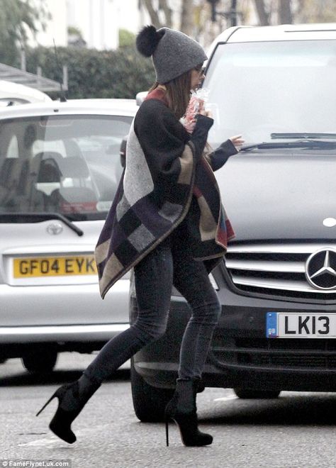 Bundled up: Victoria Beckham stepped out in London on Tuesday, rocking a Burberry blanket poncho, figure-hugging skinny jeans and a rather fun woolly bobble hat Burberry Poncho Outfit, Burberry Blanket, Burberry Poncho, Poncho Outfit, Cape Outfit, Plaid Capes, Victoria Beckham Style, Blanket Poncho, Victoria B