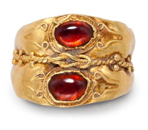 A ROMAN GOLD AND GARNET FINGER RINGCIRCA 2ND-3RD CENTURY A.D.Formed from two hoops, each rounded on the exterior, concave on the interior, expanding to the bezel, with a collar-set cabochon garnet framed by spiral and plain wire filigree, with filigree volutes on the shoulders, the two hoops joined by a spiral filigree wire punctuated by granulation, and centered by a Herakles knot of beaded wire5⁄8 in. (1.5 cm.) wide; ring size 3½PROVENANCEwith Joseph G. Gerena, New York, 1999. Ancient Roman Jewelry, Ancient Jewels, Roman Jewelry, Ancient Jewellery, Long Pearl Necklaces, Historical Jewellery, Medieval Jewelry, Pearl Jewelry Necklace, Ancient Jewelry