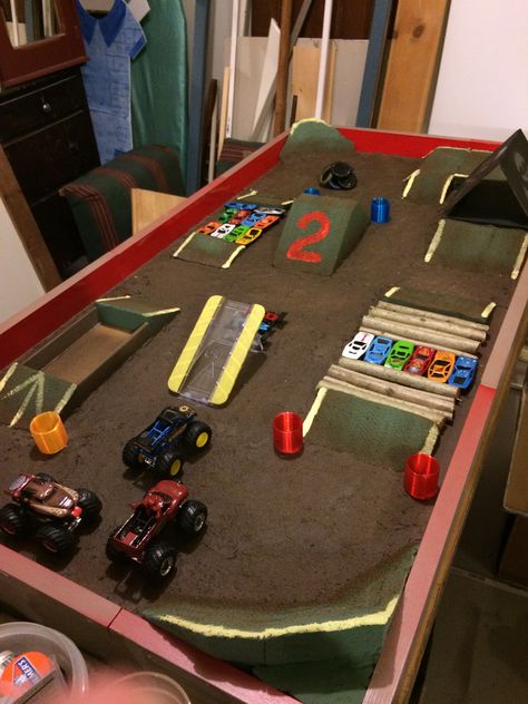 Diy Outdoor Monster Truck Track, How To Organize Monster Trucks, Monster Jam Track Diy, Cardboard Monster Truck Track, Monster Truck Arena Ideas, Diy Monster Jam Arena, Monster Truck Play Area, Diy Monster Truck Track, Monster Jam Truck Storage