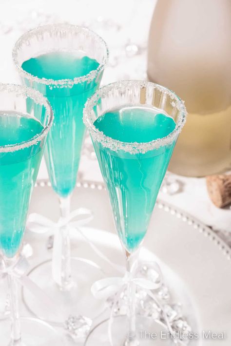 This ultra-glam Tiffany mimosa is made with sparkling wine and blue curacao to get that perfect little blue box shade. This champagne cocktail is an excellent choice for a bachelorette, a New Year celebration, a gender reveal party, or just a fun and fancy dinner party! #theendlessmeal #tiffanymimosa #mimosa #tiffanycocktail #bluemimosa #bluecuracao Pomegranate Sangria, Cafe Photoshoot, Girls Night Drinks, Wine Ingredients, Apple Cider Mimosa, Mimosa Cocktail, Honey Simple Syrup, Mimosa Recipe, 21st Birthday Ideas