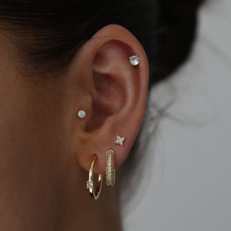 These stunning studs are a must in any jewelry collection! Spice up any stack with these babies or wear them alone for a timeless look. Studded Hoop Earrings, Ear Piercings For Small Ears Ideas, Gold Earrings 3 Holes, Three Lobe Earring Stack, 3 Stud Ear Piercing, Three Hole Earring Stack, Multiple Ear Piercings Minimalist Classy, 3 Hole Earring Stack, Earring Stack Inspo Gold