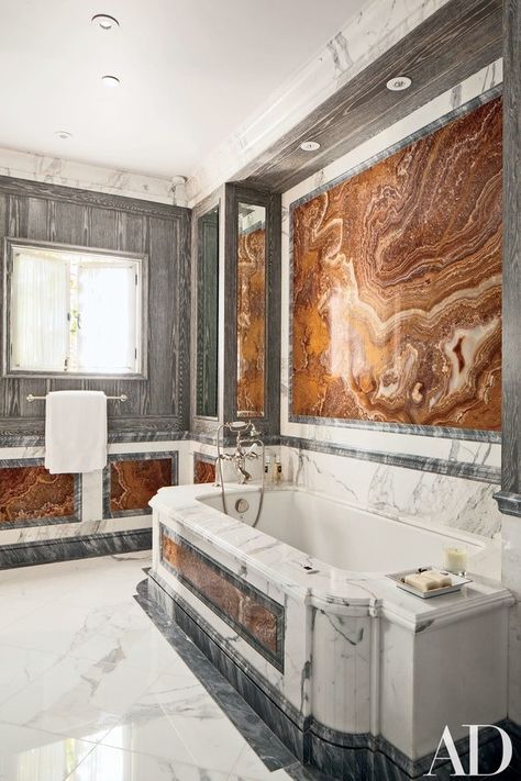 A bath is paneled in distressed oak, gray onyx, and red marble; the tub surround is made of Calacatta marble from Carmel Stone Imports, and the tub fittings are by Waterworks | archdigest.com Refinish Bathtub, Bathroom Master, Red Marble, Tub Surround, Calacatta Marble, Bathroom Design Luxury, Marble Bathroom, California Homes, Pebble Beach