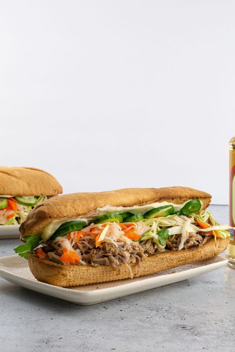 Just because grilling season is over doesn’t mean we have to make the same boring meat recipes. This pulled pork banh mi sandwich shakes things up a bit with the rich flavors from the meat and all spices. Full of protein and flavor, this sandwich has it all. Pulled Pork Bahn Mi Sandwich, Bahn Mi Sandwich Pork, Pork Banh Mi Sandwich, Pork Banh Mi, Bahn Mi Sandwich, Gluten Free Sandwich, Banh Mi Sandwich, Gluten Free Sandwiches, Gluten Free Main Dishes