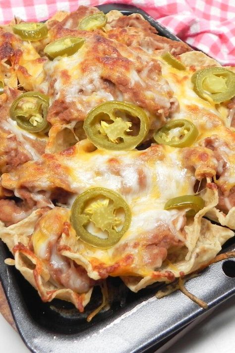 Easy Nachos with Refried Beans | "You can't go wrong with beans cheese and jalapenos. I've been making these since I was a kid and I never get tired of them." #footballrecipes #gamedayrecipes #tailgatingrecipes #superbowlrecipes #superbowlparty #superbowlpartyideas Nachos Refried Beans, Refried Beans Nachos, Refried Bean Nachos, Bean And Cheese Nachos, Nachos With Refried Beans, Meatless Nachos, Bean Nachos Recipe, Chiefs Party, Classic Meals