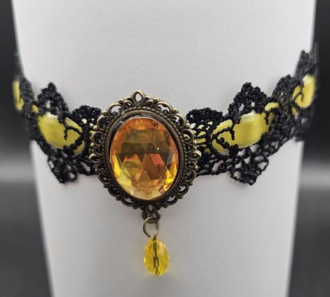 This stunning yellow gothic choker features a bold black lace design adorned with a large yellow pendant in a beautiful frame. Perfect  for gothic fashion lovers or anyone looking to make a statement or to your costume collection. Necklace length: 31.5 with additional chain of 7 centimeters Yellow Pendant, Gothic Choker, Goth Choker, Gothic Chokers, Halloween Necklace, Velvet Choker, Costume Collection, Choker Necklaces, Bold Black