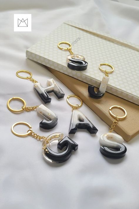 A couple of Black and White Resin Letter Keychain with Gold flakes, attached to gold metal keychain. Black And White Resin Keychain, Resin Keychain Photography Ideas, Simple Resin Crafts, Resin Photography Ideas, Keychain Photography Ideas, Black Resin Keychain, Resin Letter Keychain Ideas, Resin Photography, Giveaway Graphic