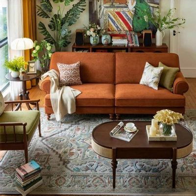 Dark Orange Couch Living Room, Color Sofas Ideas, Terra Cotta Couch Living Rooms, Retro Colorful Living Room, Orange Couch Styling, Dark Orange Couch, Burnt Orange Sofa Living Room Ideas, Orange Sofa Decor Ideas, Terracotta Couch Living Rooms