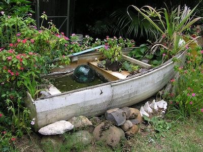 Reuse Boats: 7 Botanical Boat Designs | Green Eco Services Fish Pond Out Of Old Boat, Canoe Water Feature, Boat Fish Pond Ideas, Boat In Garden, Boat Pond Ideas, Boat Fountain, Boat Pond, Boat Planter, Boat Garden