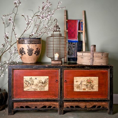 In Chinese mythology, the flowers of the peony are considered “the queen of flowers” and a harbinger of good fortune and the return of spring. A timely and perfect thought as today’s post is of a beautiful painted sideboard from Gansu Province. It has a vase with a peony in on one of its door panels. On the other door is a rural scene of rocky ravines with pine trees. All of these symbols, of streams cascading though towering bamboo groves and plum blossoms, are very important. Each one w... Lucky Objects, Ancestor Worship, Chinese Sideboard, Grain Store, Lacquered Sideboard, Painted Sideboard, Retail Store Interior, Plum Blossoms, The Golden Compass