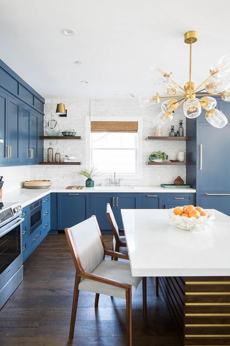 Blue and white kitchen with a dining table in lieu of an island features bleu shaker cabinets with brass hardware and white quartz countertops. White Brick Backsplash, Brick Tile Backsplash, Beach Style Kitchen, White Kitchen Remodeling, Blue Kitchen Cabinets, Herringbone Backsplash, Brick Backsplash, Kitchen Remodel Before And After, Beach Cottage Decor