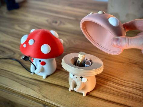 "Organize your cords and store your stuff inside these cute mushrooms! Each mushroom Cable buddy comes with a twist off cap to reveal storage for things such as Money, batteries, jewelry, chapstick! They also hold most cords and charger cables between 2-4mm wide which makes them a great addition to any desk or nightstand!  Customize yours today and each mushroom stands about 5\" tall!  We carry a wide range of colors to customize your look or choose the defaults. White Body  Tan Body  Grey Body Custom Your Choice Caps Red Pink Green Blue Custom your choice Design by Holoprops FABRICATION This Mushroom cable holder is 3D printed and these take around 8 hours to print at this size and are made on demand unless we have one premade in your color ready to go. Also note that 3D is not a perfect Kawaii 3d Print, Aesthetic Phone Accessories, Learn Pottery, Cable Management Desk, Kawaii Mushroom, Cute Mushrooms, Charger Holder, Color Palette Yellow, Cute Mushroom