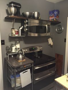 How do I hang an OTS microwave without a cabinet above? - Home Improvement Stack Exchange Microwave Shelf Over Stove, Microwave Above Stove, Over The Stove Microwave, Floating Shelves With Lights, Kitchen Floating Shelves, Microwave Shelf, Floating Shelves Bedroom, Floating Shelves Living Room, Black Floating Shelves