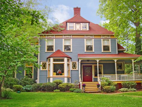 While bold, a red roof can be a good fit for gray, white, and taupe house colors. One way to be sure: Pick a variegated red shingle that folds in some of the siding color, like this oxblood roof, which incorporates hints of the blue-gray clapboards. Similar to shown: Supreme in Spanish Red, about $81 per square; Owens Corning House Exterior Red Roof, Blue House With Red Roof, House With Red Roof, Cottage Style Doors, Paint Combos, Green House Exterior, Red Roof House, Property Ideas, Shingle Colors