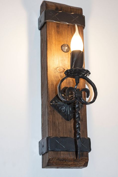 "Rustic wall light handmade made out of pine wood beam and wrought iron. Wood, iron and light combined is aesthetic and appropriate for many styles. Medieval lighting made using the best modern materials. Light will be made and shipped in a few days after you place your order. Beam is painted in dark lacquer. Iron is painted in hammered black. Easy fitting to wall with hangers mounted on back! Height is 50cm (20\"). may slightly vary. Can be installed in any country! 110/230V Comes with e14 bulb Medieval Lighting, Funky Lamps, Rustic Oak Furniture, Steampunk Furniture, Rustic Wall Lighting, Medieval Decor, Rustic Light Fixtures, Entrance Gates Design, Wood Beam