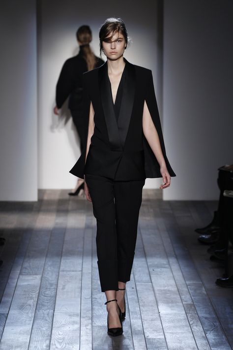 LOOK 28  Lin K  Black double crepe/faille cape jacket with black open weave wool tapered cuff trousers. | Victoria Beckham RTW AW13 | via Victoria Beckham Tuxedo Designs, Women's Tuxedo, Chloe Fashion, Tuxedo Women, Cocktail Wear, Wedding Guest Style, White Tuxedo, Tuxedo Dress, Silky Blouse