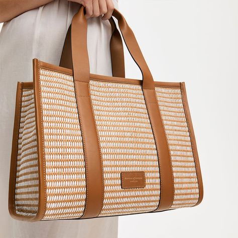 A statement bag for the city or a staple for the beach, our Henley Raffia Tote in basket woven raffia with tan leather accents combines style and practicality. Handcrafted from raffia and full-grain leather, tan and white raffia combine for a fresh, modern look. The stunning tote bag features two mobile-sized pockets in the otherwise open, spacious interior; perfect for meeting the demands of a long summer's day. Unstructured and soft, the tote's laid-back aesthetic is complemented by the luxury Raffia Bag Aesthetic, Armani 2024, Designer Travel Bags, Tan Leather Tote, Woven Leather Tote, Museum Gift Shop, Museum Gift, Bridal Shoes Flats, Basket Woven