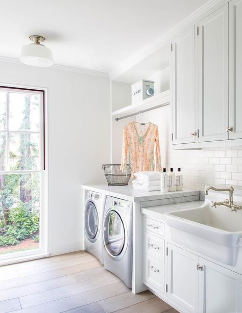 White laundry room features white cabinets adorned with vintage latch hardware paired with carrera marble countertops and a white subway tile backsplash. White Laundry Room, Modern Farmhouse Laundry Room, Laundry Room Storage Shelves, White Laundry Rooms, Laundry Room/mud Room, Drying Room, Small Laundry Room Organization, Room Storage Diy, Dream Laundry Room