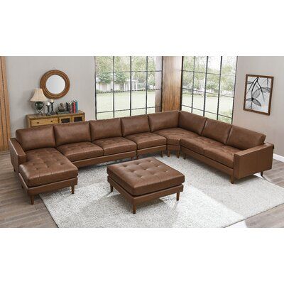 This right-hand-facing corner sectional features a modular L-shaped design that seats up to seven people, just in time for the big game. It has a solid wood frame that rests on walnut-hued tapered dowel legs for a mid-century modern touch. Upholstered in a leather match fabric, the cushions are filled with foam and supported by coil springs to help limit sagging over time. The seats of the sectional and the accompanying ottoman are button-tufted for an extra layer of texture. Square arms, cushio Leather Sectional Living Room, Desert Cottage, Ottoman Leather, Interesting Furniture, Leather Chaise Sectional, Faux Leather Sectional, Brown Sectional, Genuine Leather Sofa, Leather Sectional Sofas