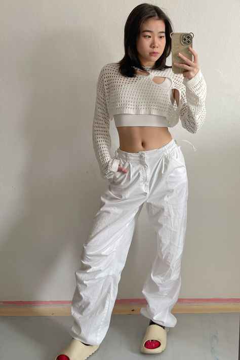 y2k style, outfit inspo, ootd, white parachute pants, streetwear, yeezy slides, knite sweater with hole, outfit with white parachute pants White Sweater With Holes, Parashoot Pants Outfit, White Parachute Pants Outfit, White Parachute Pants, Parachute Pants Outfit, Korean Bag, Acubi Fashion, Yeezy Slides, Pants Streetwear