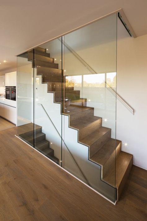 The home’s ground level features engineered oak flooring. The staircase, which leads to the house’s upper and lower levels, was constructed out of steel folded plate and subsequently clad in timber. Enclosed Staircase, Glass Balcony Railing, Glass Stair, Engineered Oak Flooring, Escalier Design, Glass Staircase, Floating Stairs, Stair Case, Home Stairs Design