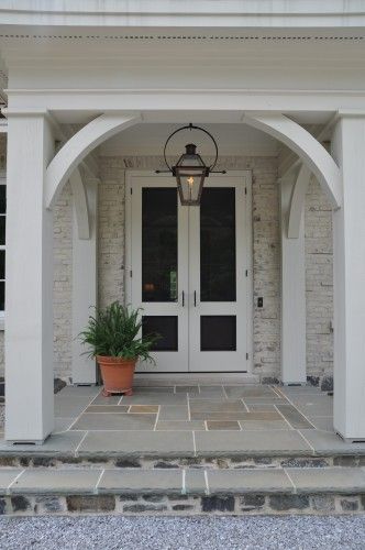 Beautiful wood bracing creates a design element in this entry. Bevolo French Quarter Lantern on yoke bracket with ladder rack. Front Door Lighting, Double Door Entrance, Building A Porch, French Doors Exterior, Porch Columns, Porte Cochere, Traditional Exterior, House With Porch, Front Entrance