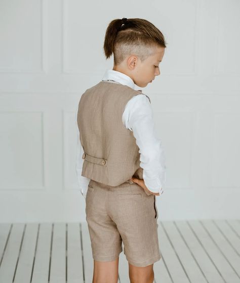 A linen vest and shorts set for boys is a great choice for weddings, offering both style and comfort. Here are some ideas to consider: 
1. Pastel Colors: Soft pastel shades like light blue, mint green, or blush pink add a touch of color while still keeping the outfit elegant and wedding-appropriate. 
2. Accessories: Complete the look with a matching bow tie or necktie, and consider adding suspenders for an extra cute and polished appearance. 
3. Comfort: Linen is breathable and comfortable, i... Boys Wedding Outfit, Outfit With Vest, Vest Linen, Wedding Outfit For Boys, Vest And Bow Tie, Linen Outfit, Outfit Elegant, Bearer Outfit, Linen Vest